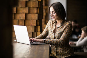 Mulher caucasiana usando laptop em uma mesa